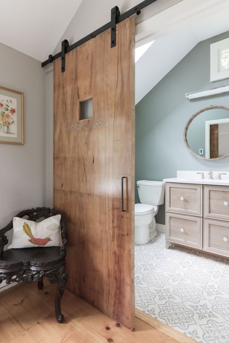 Barn door in a bathroom remodel designed by Marlene & Co to offer privacy