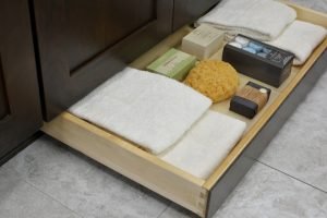 Toe-kick storage in a bathroom cabinet