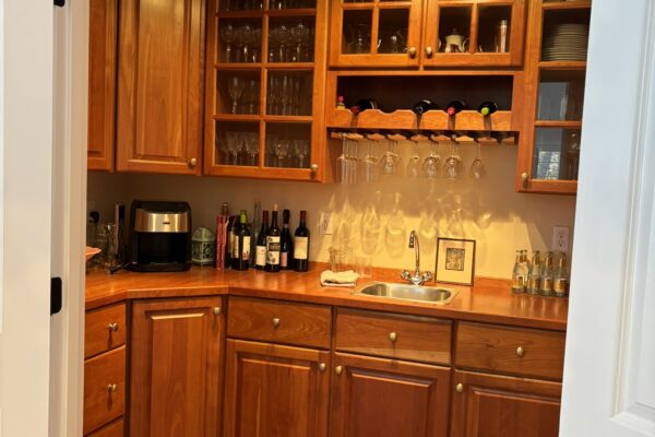 The underutilized pantry and wet bar area with outdated cabinetry